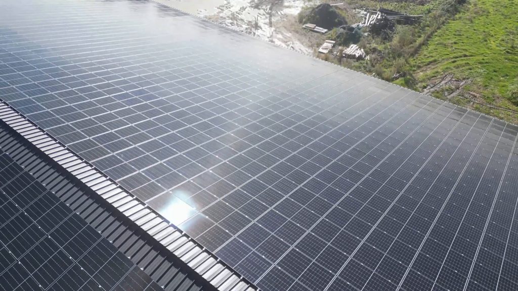 Installation de panneaux solaires sur une toiture existante en tôle ondulée, optimisant l'énergie solaire tout en conservant la structure d'origine.